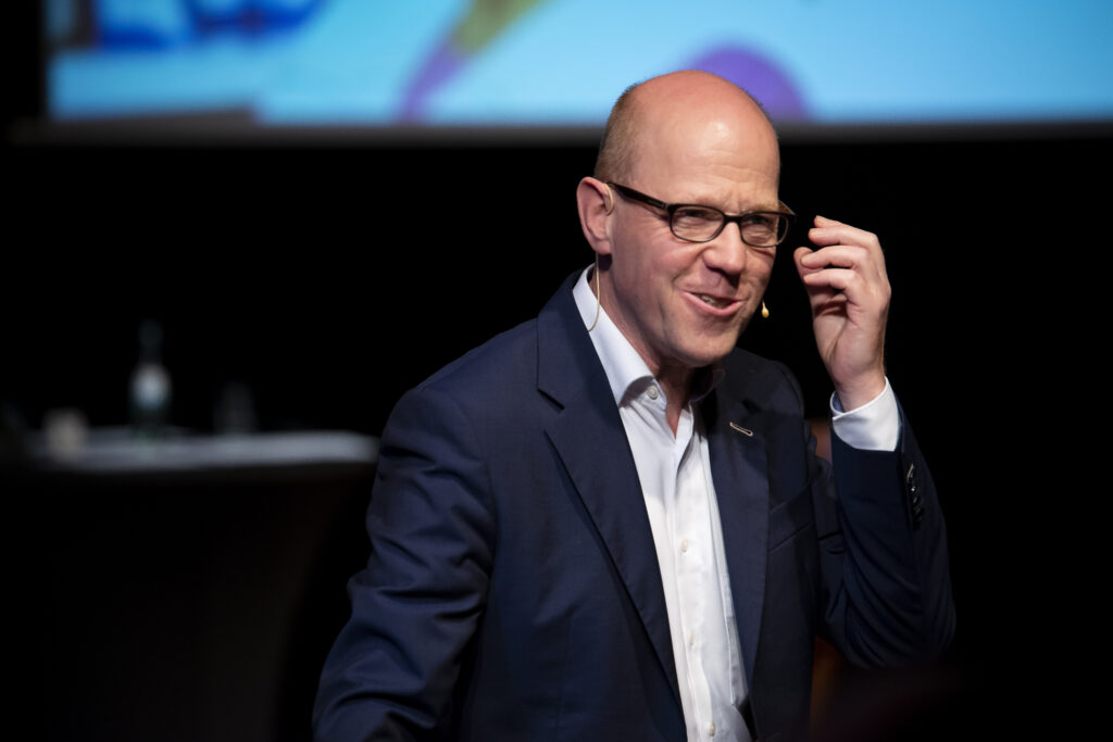 Lutz Herkenrath spricht auf der Bühne